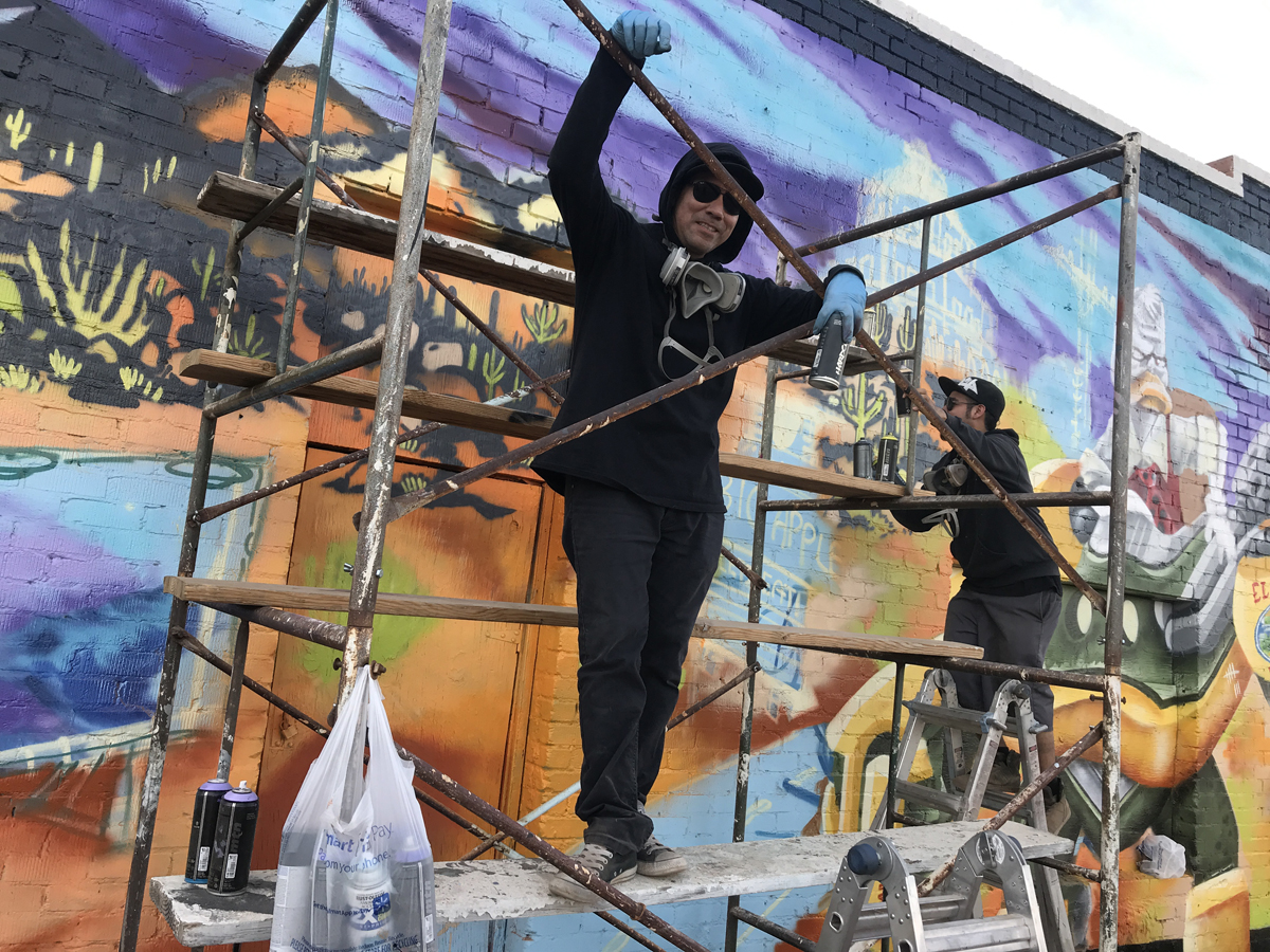 An image of Such and Champ Styles painting a mural in Phoenix, a discipline that faces new guidelines from the city.