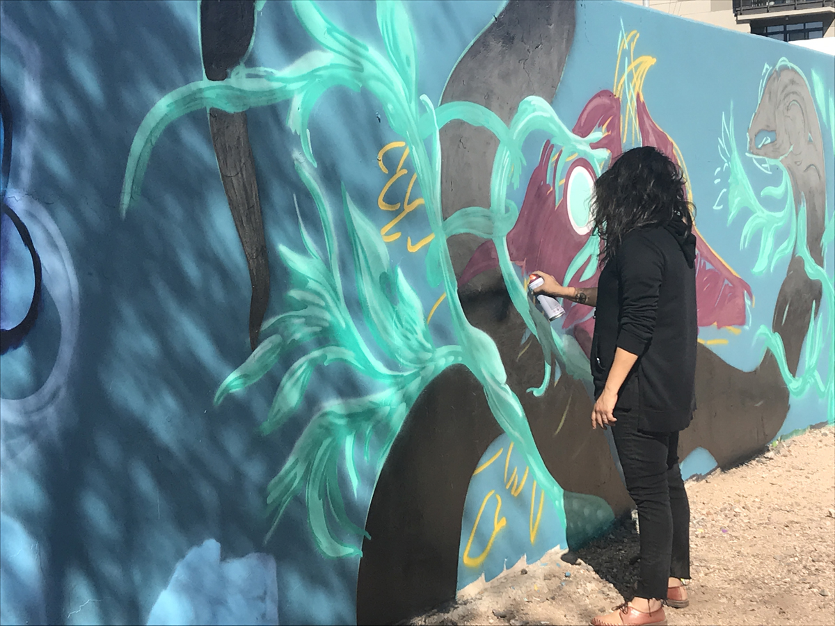 Ashley Macias works on a mural in Phoenix.
