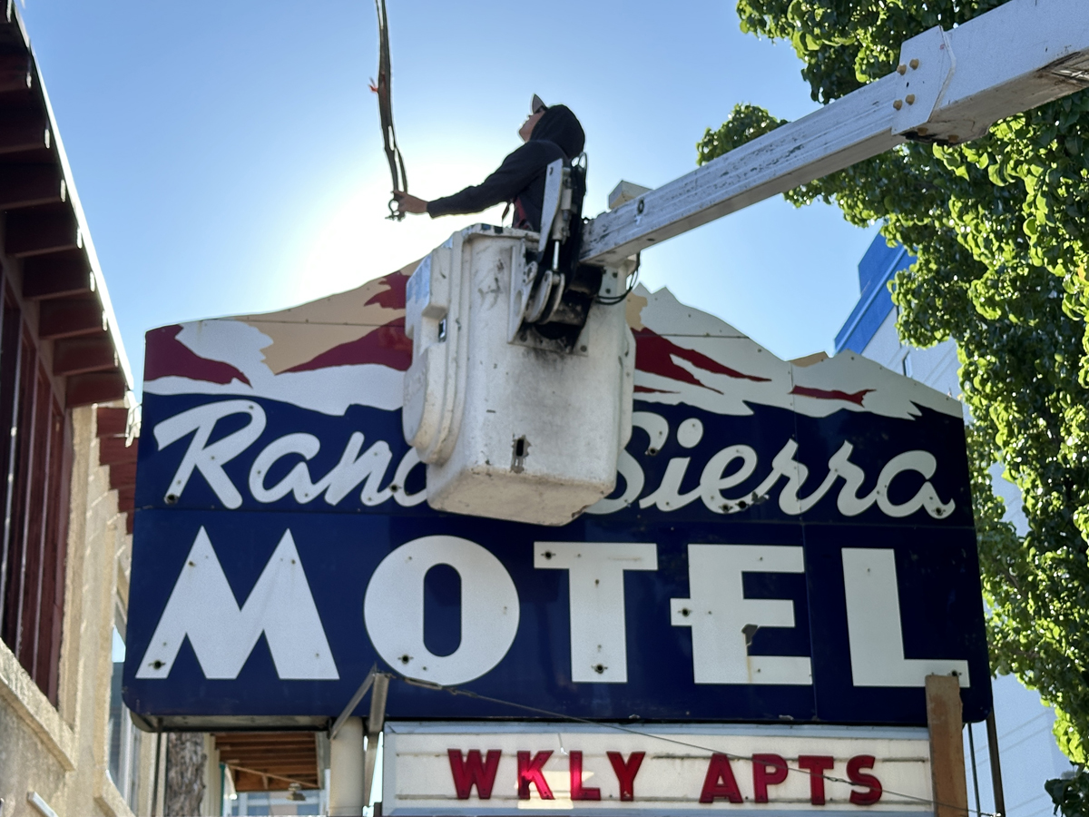 Neon collector and museum founder Will Durham attaches a neon sign to a crane.