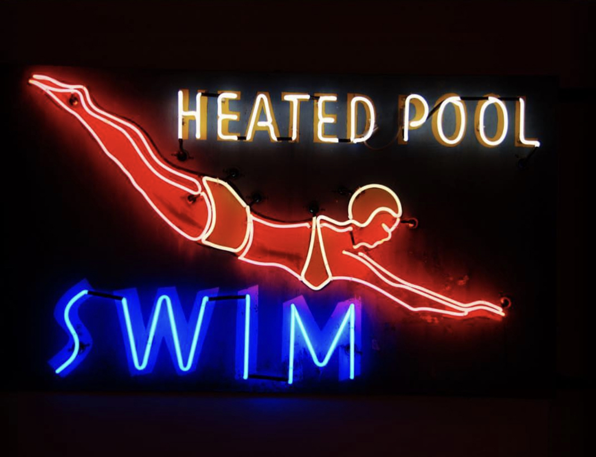 Neon sign that reads "Heated Pool Swim" in a new design museum in Reno, Nevada.