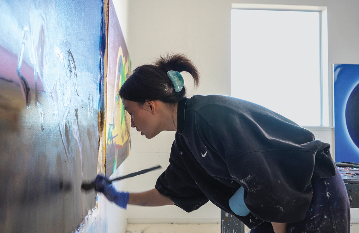 An artist paints in her studio at the Roswell Artist-in-Residence Program.