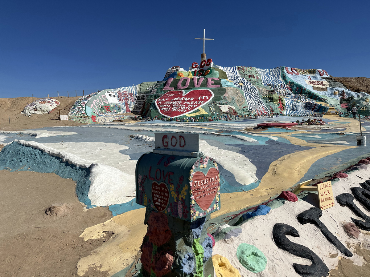 Salvation Mountain with a mailbox in front of it labeled "God."