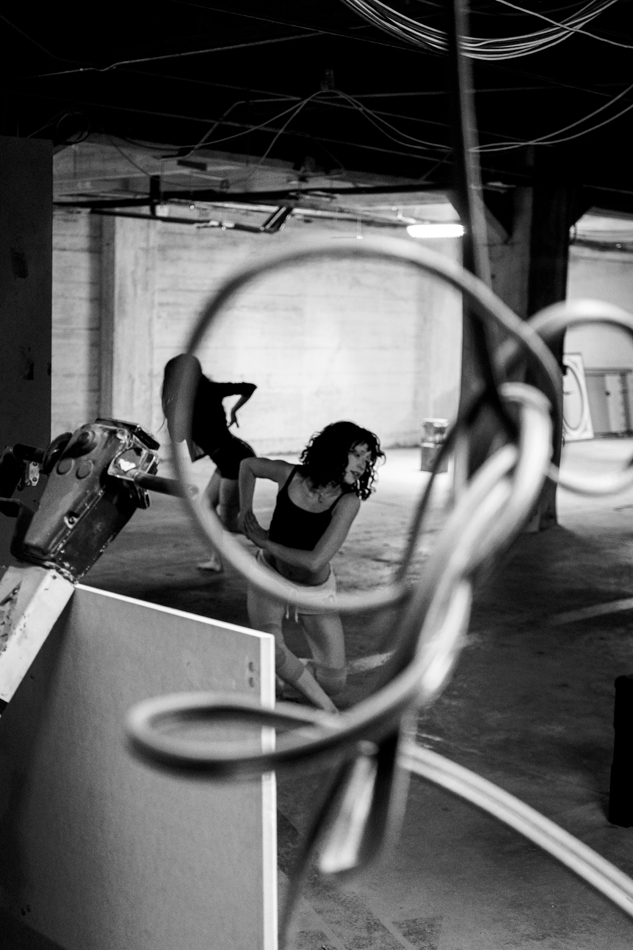 Photo of a dancer, viewed through a tangled power cord.
