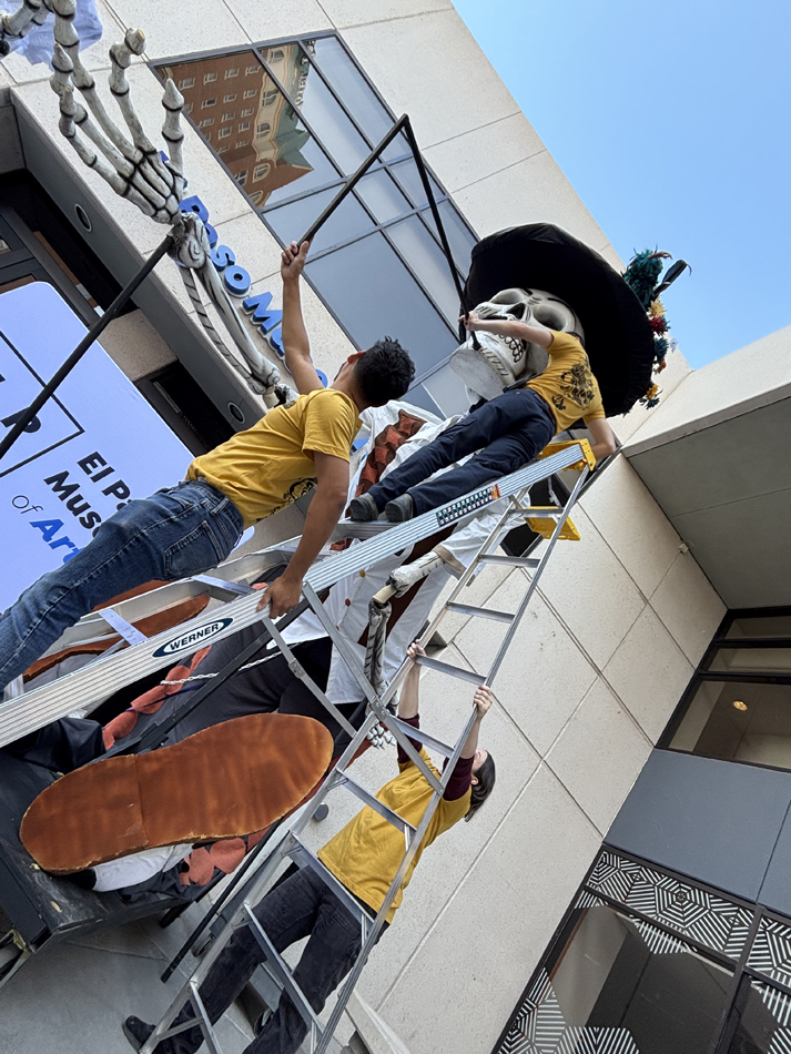 Registrars install a large-scale Day of the Dead sculpture at El Paso Museum of Art.
