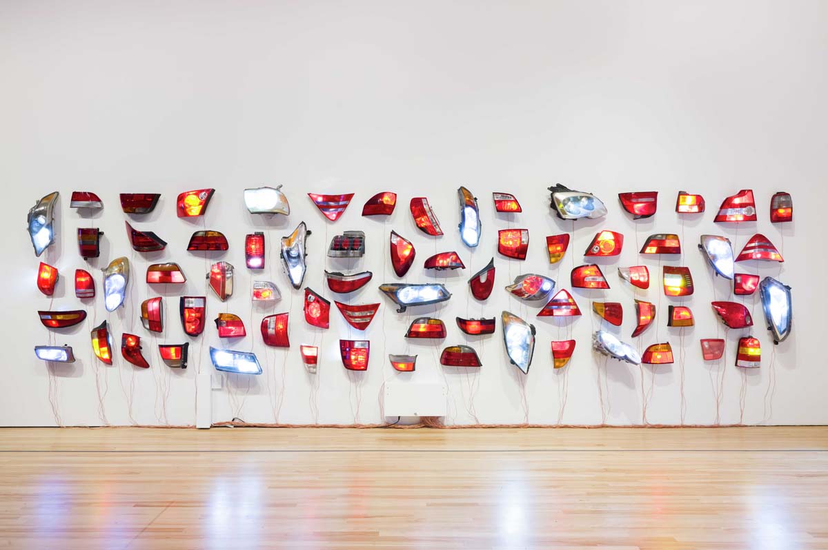 Madeline Hollander's wall installation of 73 automobile headlights and taillights customized with LEDs and real-time software program