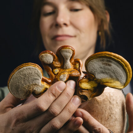 Sculptor Kate Casanova holding mushrooms.
