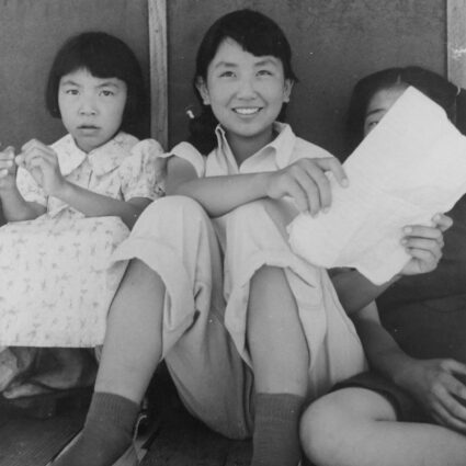 Photograph by Dorothea Lange of young girls imprisoned at a Japanese American incarceration camp.